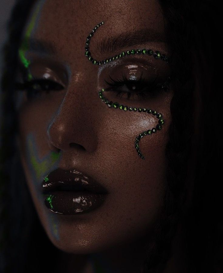 dark lipstick, black girl, green snake rhinestones, eyebrows, clear skin, lashes, brown eyes Dark Green Sparkly Makeup, Green Sparkly Eye Makeup, Dark Rhinestone Makeup, Alien Makeup Green, Green Rhinestone Makeup, Dark Festival Makeup, Black Rave Makeup, Concert Eyeliner, Techno Party Makeup