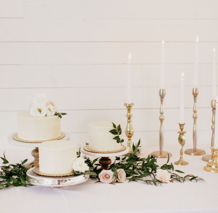 a table topped with lots of white cakes and candles