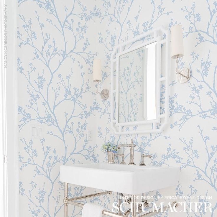 a white sink sitting under a bathroom mirror next to a wall mounted faucet