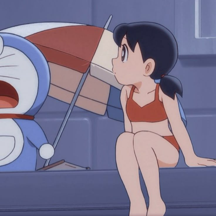 a woman in a bathing suit sitting on the ground next to a cartoon character with an umbrella