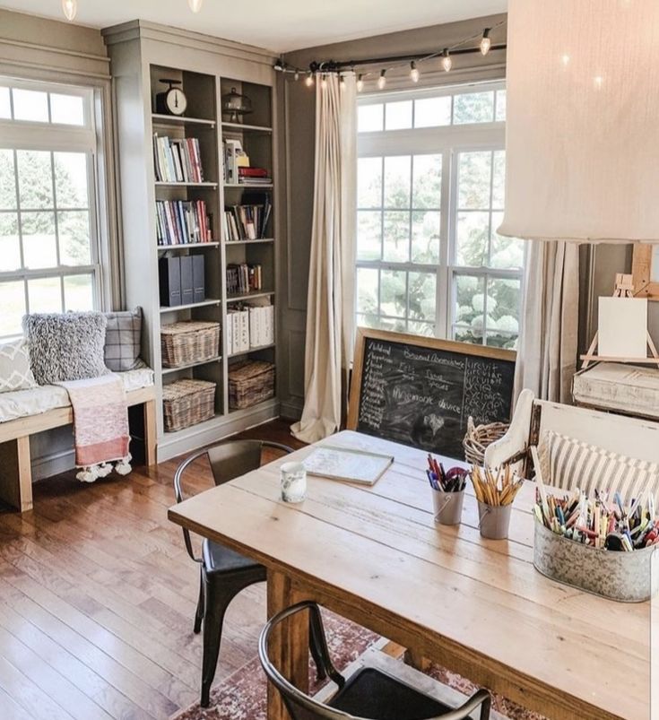 a living room filled with furniture and a wooden table in front of a large window