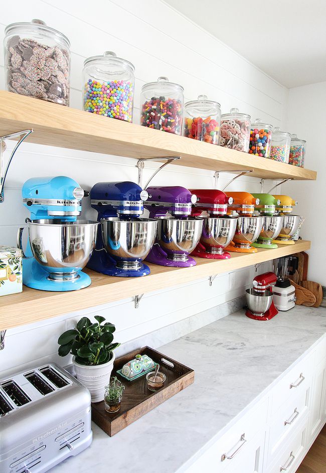 the shelves are filled with many different colored mixers