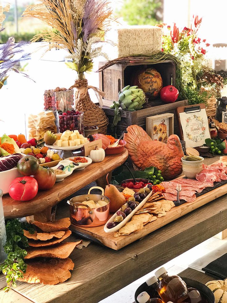 an assortment of fruits and vegetables on a table with other foods in front of it