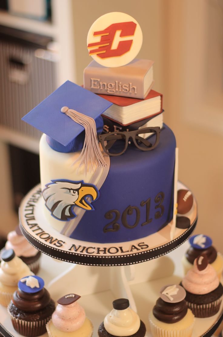 a graduation cake with cupcakes and books on top