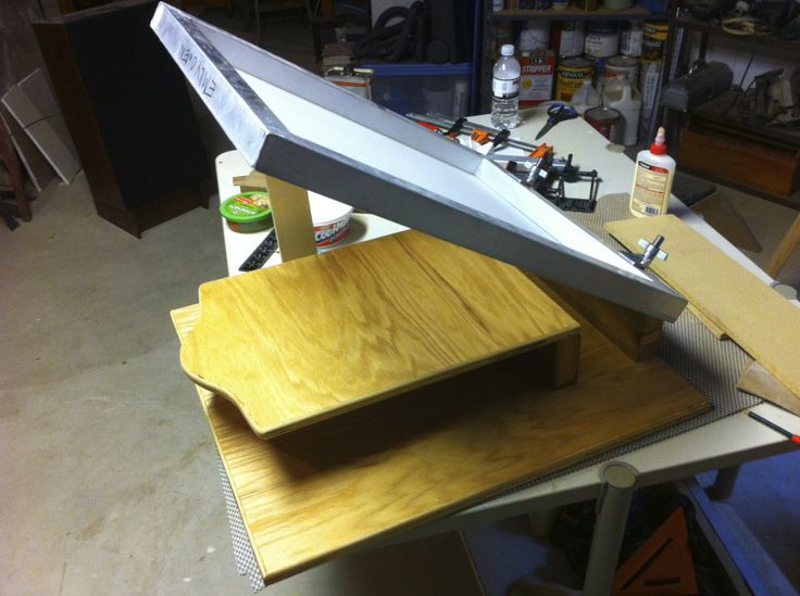 a large metal object sitting on top of a wooden table in a room filled with tools