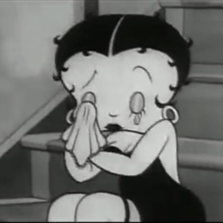 a cartoon character sitting on the ground with her hand near her face and looking at something