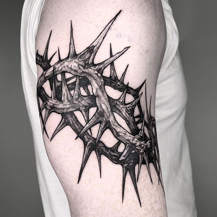 a black and white photo of a man's arm with a crown tattoo on it