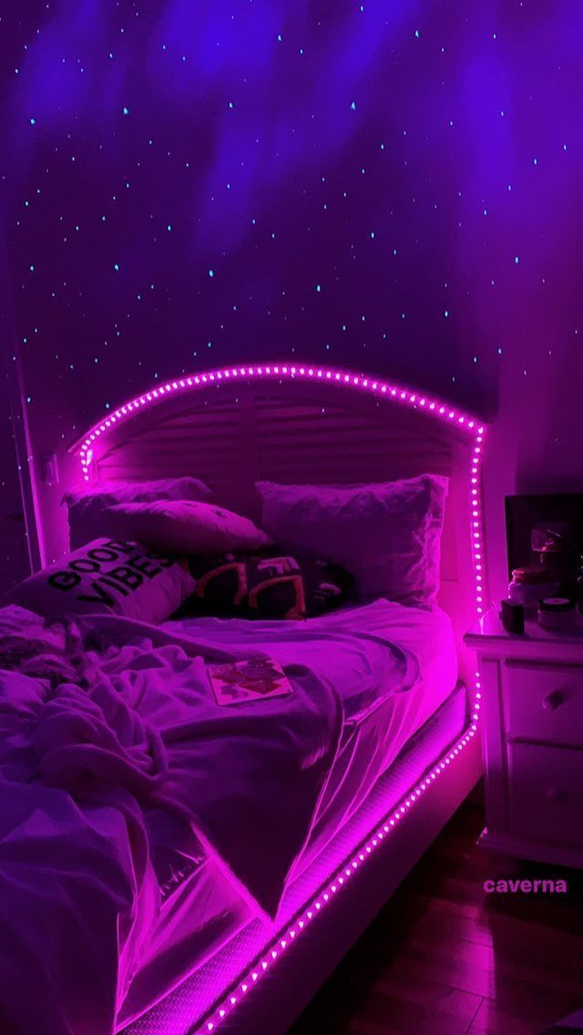 a bed in a room with purple lights on the headboard and foot board,