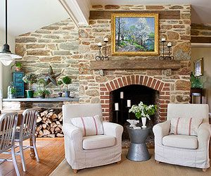 a living room with two chairs and a fire place in front of a stone fireplace