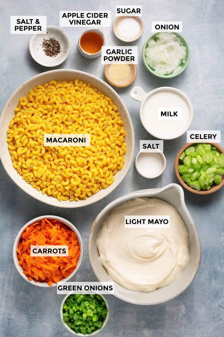 ingredients to make macaroni and cheese are shown in bowls on a gray background