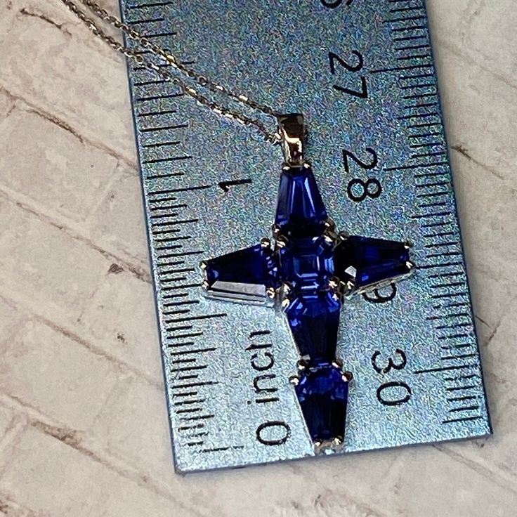 "Blue Sapphire Cross Pendant with trapezoid stones #7035 -Approximate total carat weight: 5.50ctw diamond equivalent -Center Stone Size: approx. 0.50ct/each diamond equivalent -Center Stone Shape: Asscher cut 5x5mm -Gem Type: lab created blue sapphire -Stone Clarity: VS2 -Stone Color: F -Moh's Scale: 9 hardness -Stone Size: approx. 1.00ct/each diamond equivalent -Stone Shape: 5 Elongated trapezoid 7x5mm each -Gem Type: lab created blue sapphire -Stone Clarity: VS2 -Stone Color: F -Moh's Scale: 9 Blue Crystal Jewelry With Gemstones, Blue Baguette Cut Jewelry For Anniversary, Blue Diamond Gemstone Jewelry, Blue Diamond Pendant Jewelry, Blue Diamond Jewelry With Emerald Cut, Blue Diamond Cut Cubic Zirconia Jewelry, Blue Diamond Jewelry With Diamond Cut, Sapphire Jewelry With Diamond Baguette Cut, Blue Diamond Jewelry For Gifts