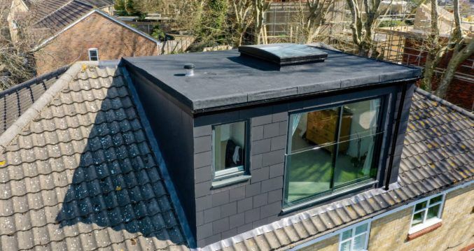 an aerial view of the roof of a house with two windows and a skylight