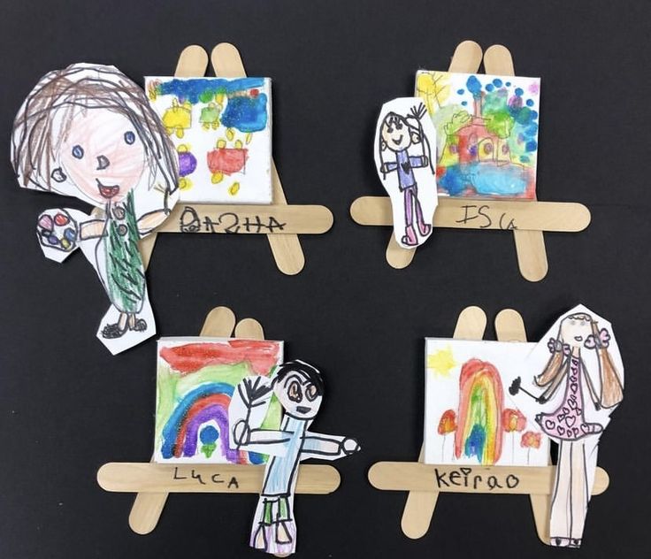 four children's artwork on popsicle sticks