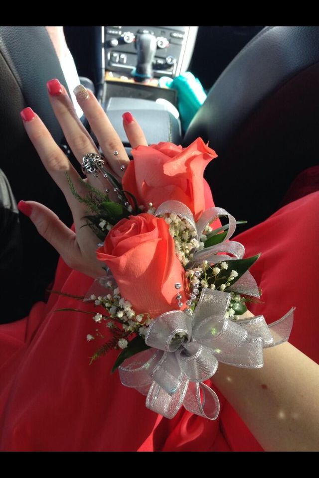 a woman in a red dress is holding flowers and wearing an engagement ring on her finger