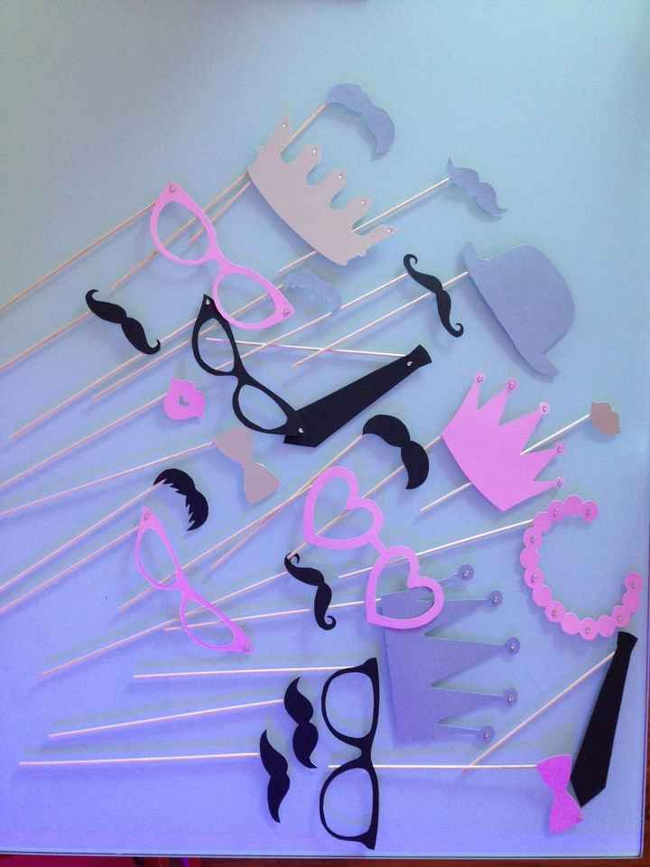 a table topped with lots of cake toppers next to glasses and mustaches on sticks