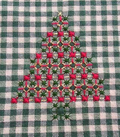 a green and white checkered table cloth with a red christmas tree on the front