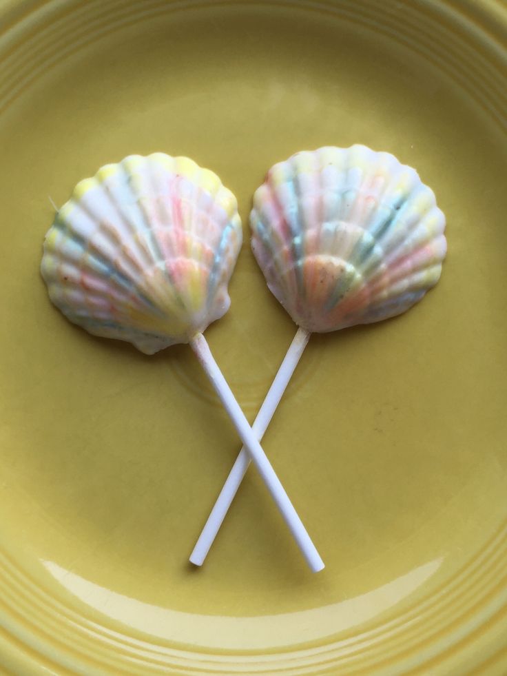 two candy lollipops on a yellow plate