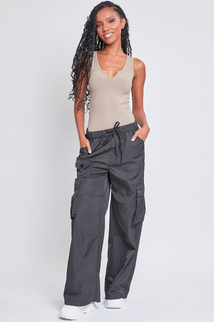 Every day is a new chance to wear our Women’s Relaxed Fit Cargo Pants. This high-waisted nylon pant features a relaxed fit for both style and comfort, ensuring you’ll look good and feel good throughout the day. Includes classic front pockets, three cargo pockets with button closures, and faux back pockets for maintaining a smoothing effect on your bum. These trendy pants are detailed with metal d-rings on the front belt loops and a drawstring waist so you can adjust the fit to your liking. Style Nylon Bottoms With Elastic Waistband For Work, High-waisted Parachute Pants With Multiple Pockets, Wide Leg Nylon Pants With Elastic Waistband, Wide-leg Nylon Pants With Elastic Waistband, Spring Nylon Straight Leg Bottoms, Nylon Wide-leg Pants With Elastic Waistband, Utility Wide Leg Nylon Bottoms, Relaxed Fit Wide Leg Nylon Parachute Pants, Utility High-waisted Parachute Pants With Hip Pockets