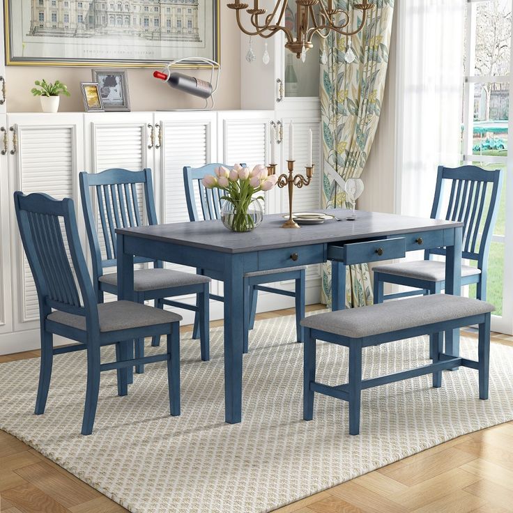 a dining room table with blue chairs and a chandelier