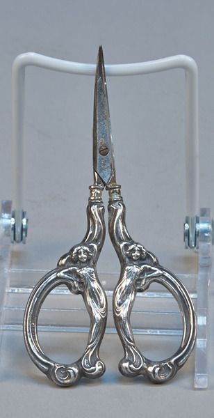 a pair of scissors sitting on top of a clear stand