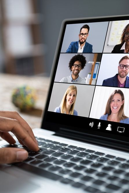 a person is using a laptop with several people on the screen