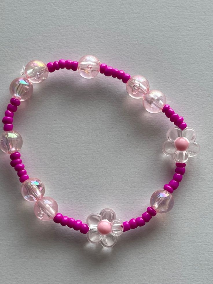 This is our beautiful elastic pink beaded bracelet, w/ different shades of pink and floral theme. Spring Pink Beaded Jewelry, Trendy Pink Hand-strung Jewelry, Trendy Hand-strung Pink Jewelry, Spring Pink Jewelry With Colorful Beads, Spring Pink Beaded Bracelets With Colorful Beads, Pink Bracelet For Spring, Pink Bracelet Jewelry For Spring, Spring Pink Beaded Bracelets, Pink Casual Beaded Bracelets For Spring