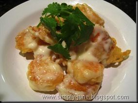 a white plate topped with shrimp covered in sauce and garnished with parsley