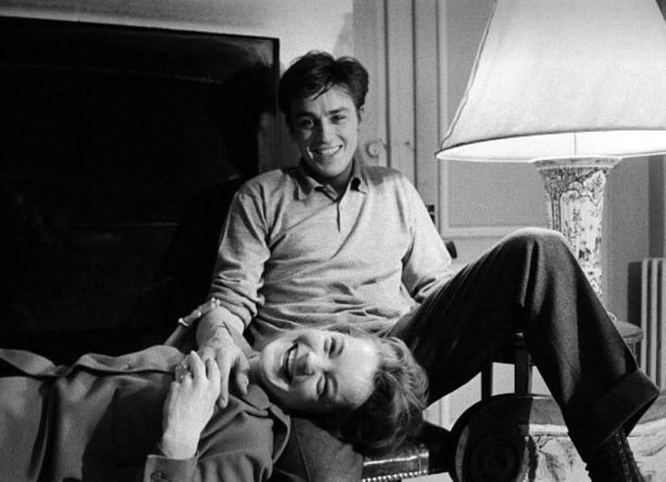 black and white photograph of two men sitting on a bed with one holding the other's head