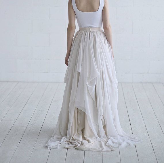 a woman in a white dress standing on a wooden floor with her back to the camera