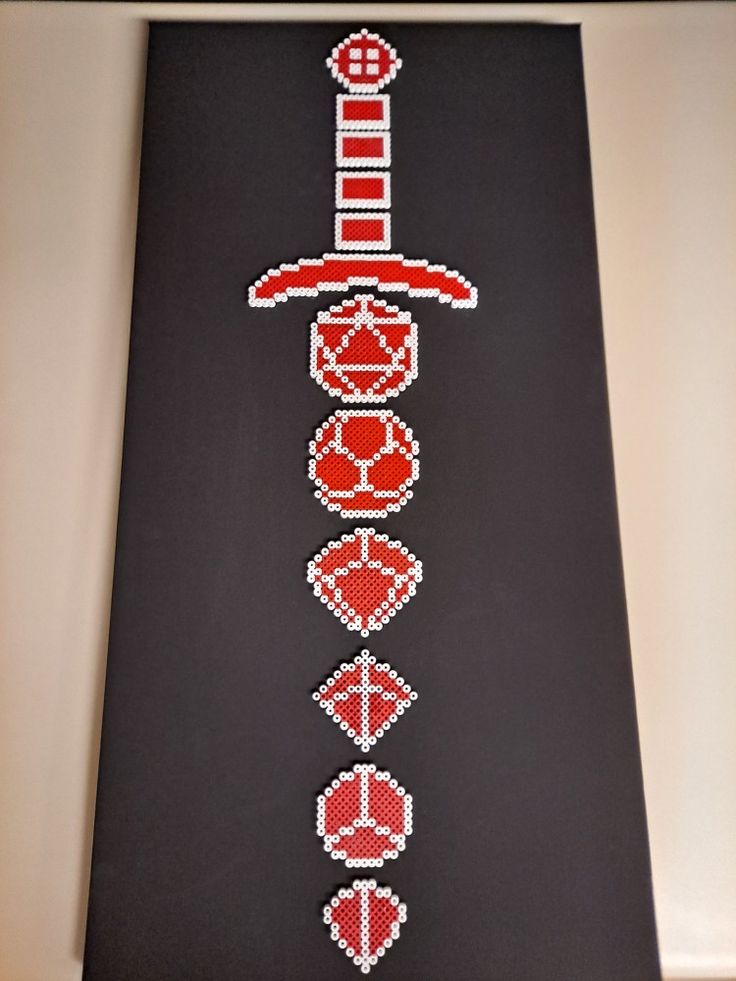 an image of a cross stitch pattern on a black board with red and white designs