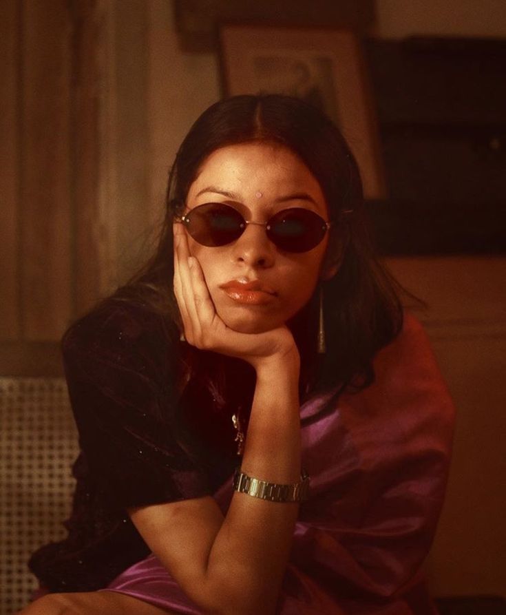 a woman wearing sunglasses is sitting down