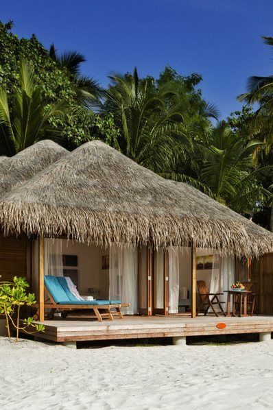 a small hut on the beach with thatched roof