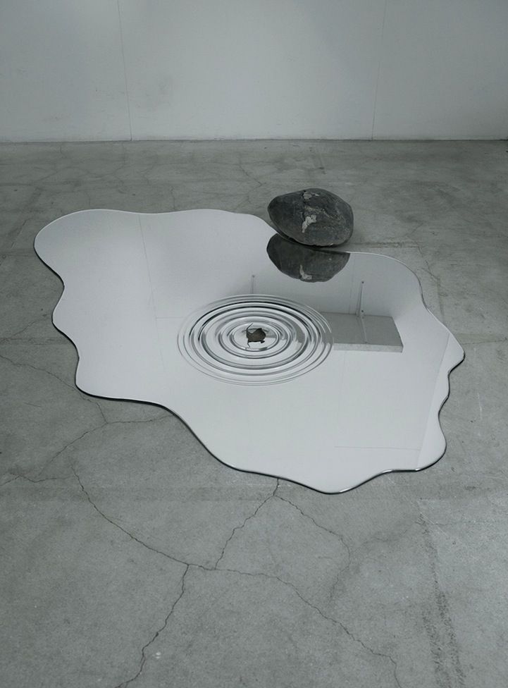 a black and white photo of a rock in the middle of a floor drain hole