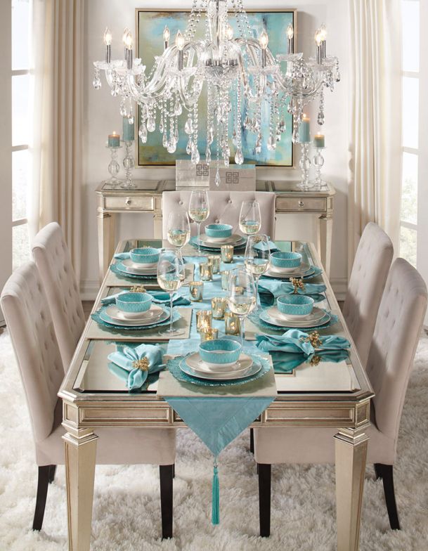 the dining room table is set with blue dishes and place settings