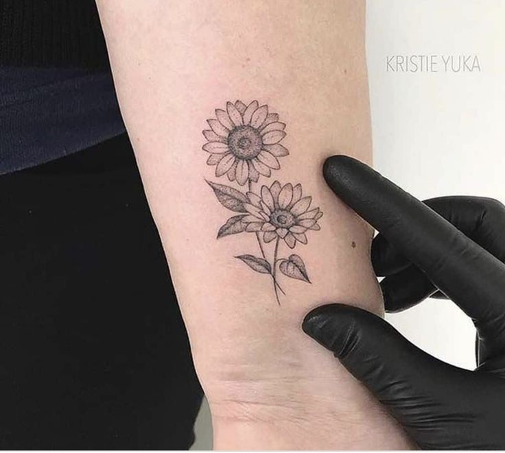 a woman's arm with a tattoo on it and a sunflower in the middle