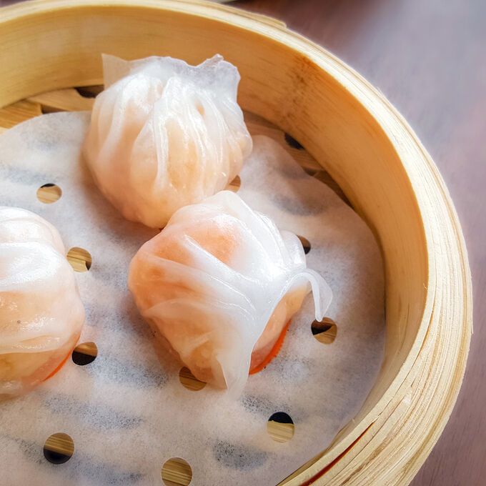 three dumplings in a wooden bowl on a table