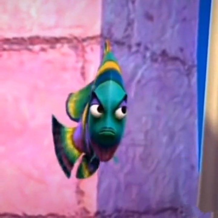 an animated fish is hanging upside down from the ceiling in front of a pink wall