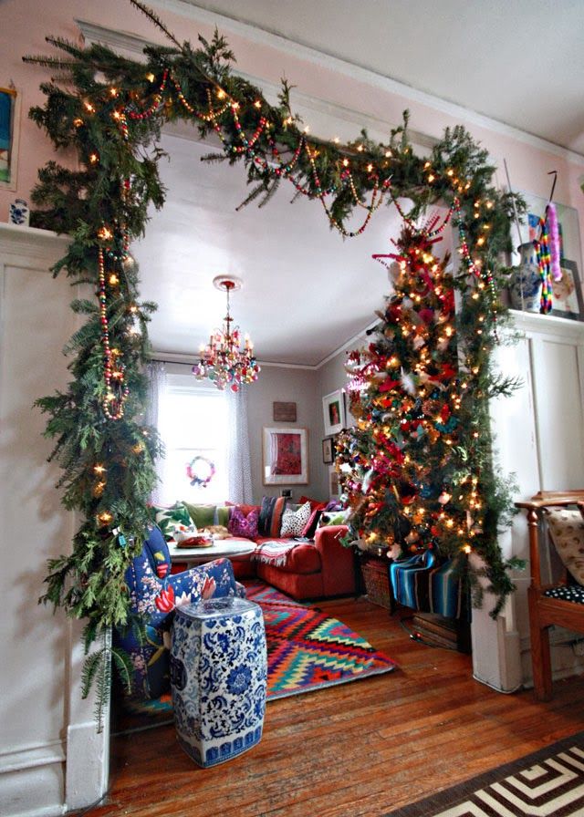 a living room decorated for christmas with garland and lights