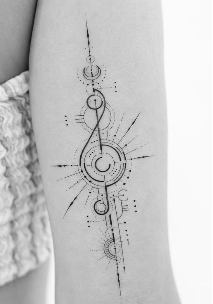 a black and white photo of a woman's arm with music notes on it