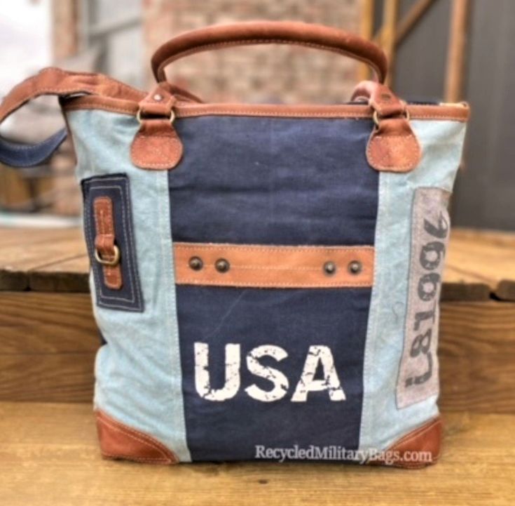 Blue two tone tote canvas and leather bag crafted of repurposed and upcycled sustainable Military Canvas into this great purse or tote bag. Plenty of room for everything you need. Convenient front pocket and adjustable crossbody strap make it the perfect bag to show your pride with ease, d comfort and style! A perfect gift for all those patriotic peeps, military moms, wives and all that just love a quality bag. 17" x 14.5" x 4" <<-- Please Check the DIMs! Fully Lined Inside Zip top Closure Leath Upcycled Tote Shoulder Bag For Everyday, Upcycled Everyday Tote Shoulder Bag, Everyday Upcycled Tote Shoulder Bag, Vintage Canvas Shoulder Bag For Errands, Upcycled Satchel Bag For Everyday Use, Vintage Canvas Shoulder Bag For On-the-go, Blue Canvas Shoulder Bag With Leather Trim, Daily Use Upcycled Satchel Shoulder Bag, Everyday Upcycled Satchel Bag