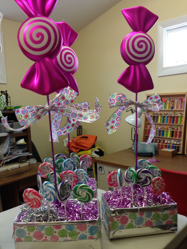 two boxes filled with candy and lollipops sitting on top of a table