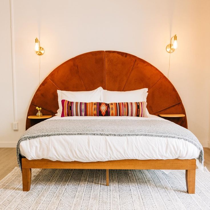 a bed with a headboard made out of wood and pillows on top of it