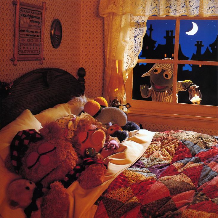 there is a bed with many stuffed animals on it in front of an open window