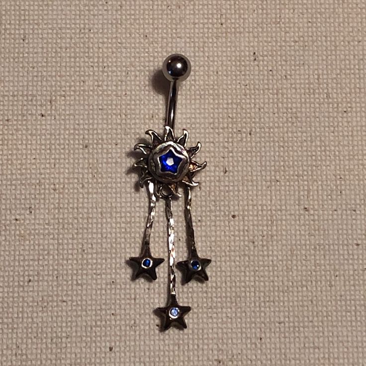 a blue and white brooch sitting on top of a piece of cloth