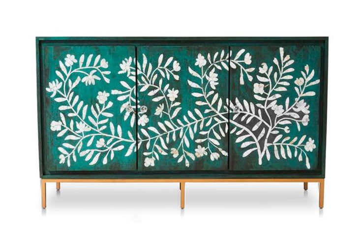 a green cabinet with white flowers and leaves painted on it