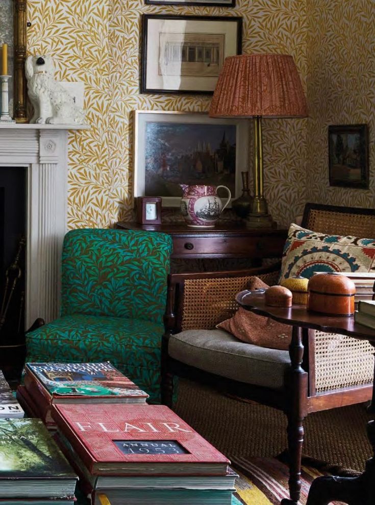 a living room filled with furniture and a fire place in front of a wallpapered wall