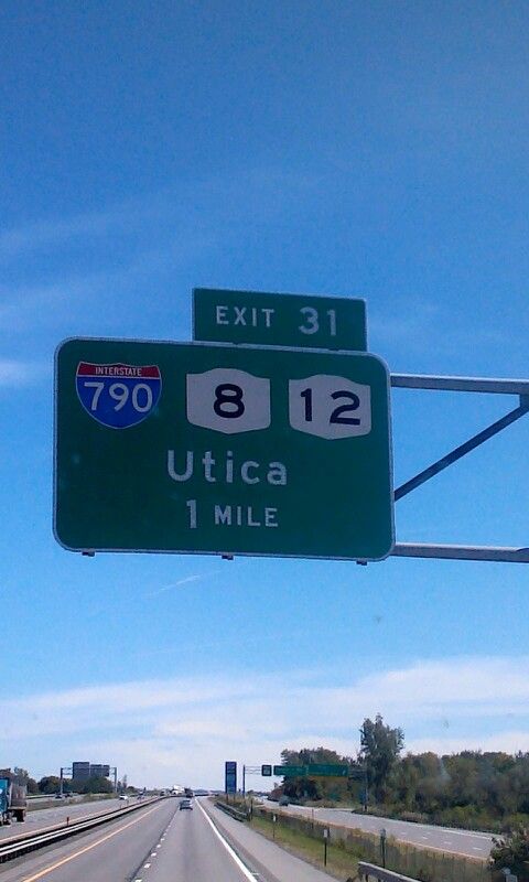 an exit sign above a highway on a clear day