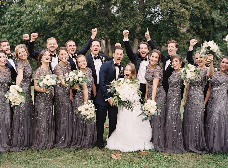 a group of people standing next to each other on top of a lush green field