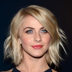 a woman with blonde hair and blue eyes wearing a black dress looking at the camera