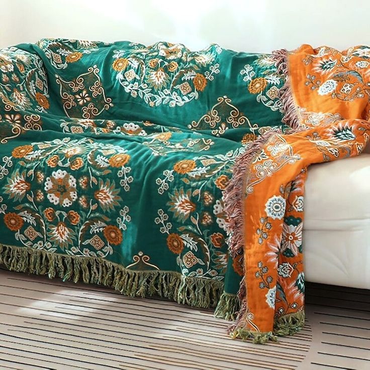 a couch covered in a green and orange blanket